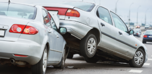 Car Accident Scene - A severe rear-end crash shows a car lifted onto another on a busy highway