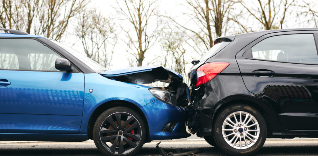 Two cars involved in a rear-end collision, with the blue car's front damaged and the black car's rear dented