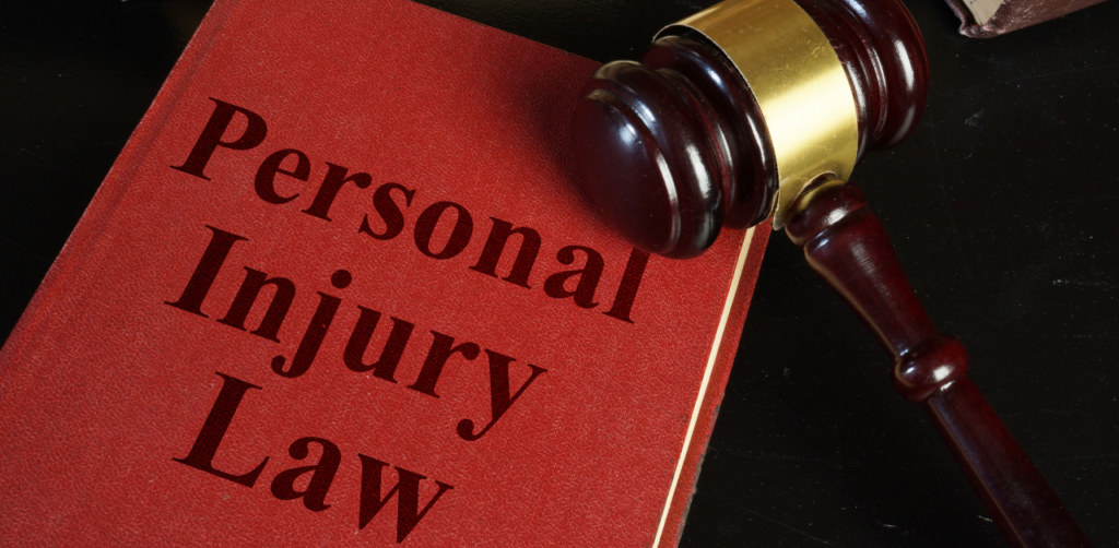 A gavel placed next to a red book titled "Personal Injury Law"