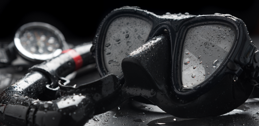 Close-up of black scuba goggles and snorkel with water droplets, suggesting recent underwater use