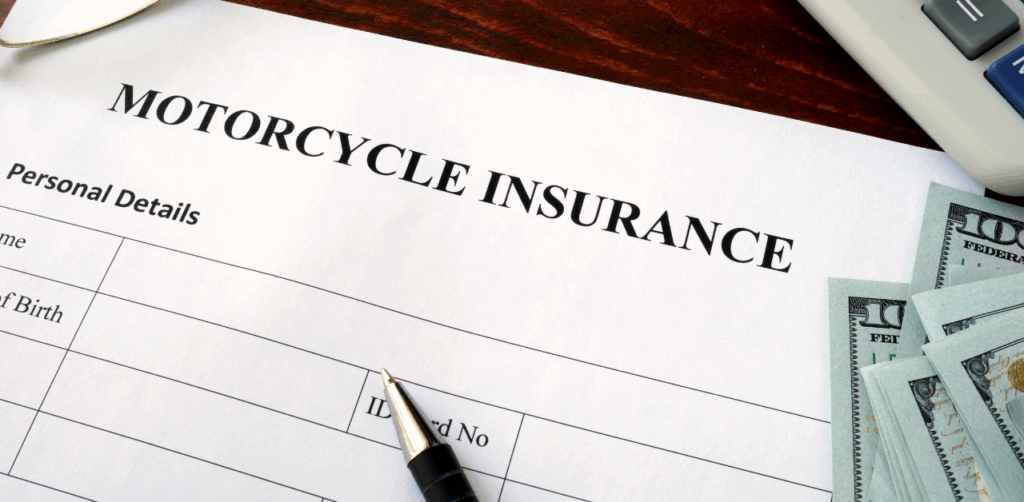 Motorcycle insurance form with a pen and cash on a wooden desk, emphasizing vehicle coverage paperwork