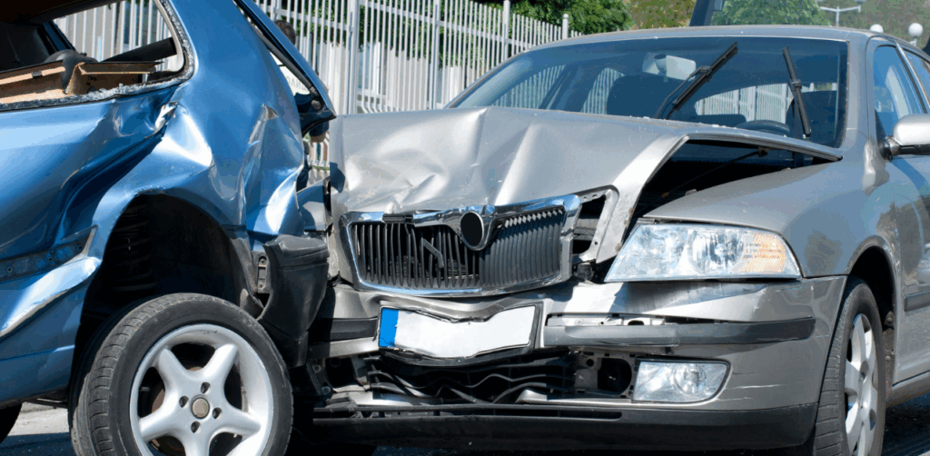 Paramedics load crash victim into ambulance as blurred red car passes at car accident scene