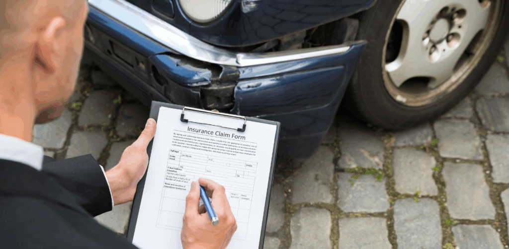 Insurance adjuster filling out a claim form on a clipboard while inspecting damage to a blue car
