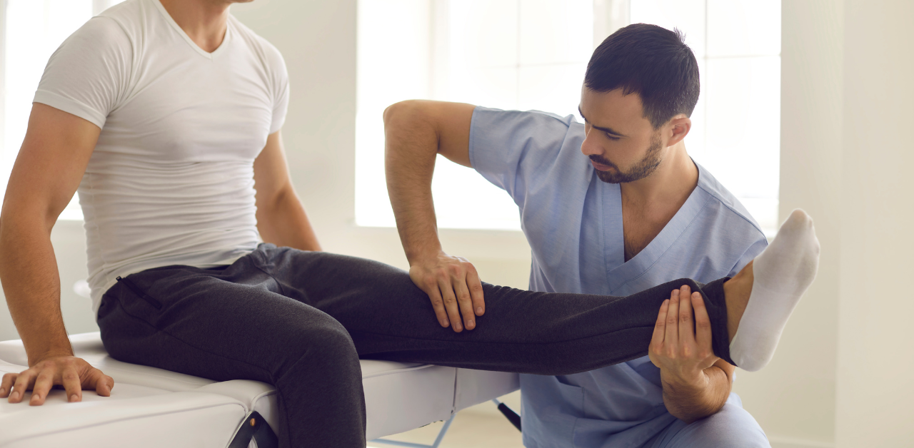 Physical therapist assisting a patient with leg mobility during a rehab session