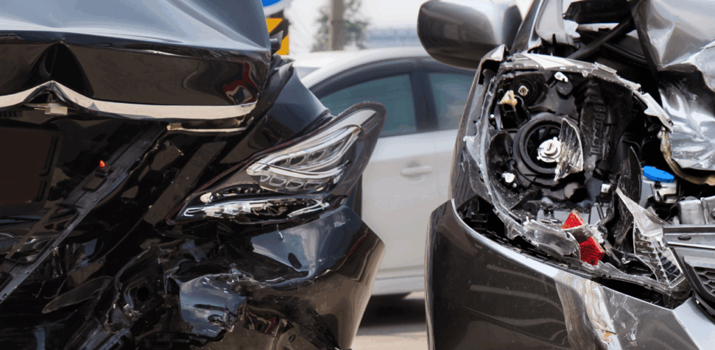 Two severely damaged car fronts after a collision, showing crash impact and pedestrian safety risk