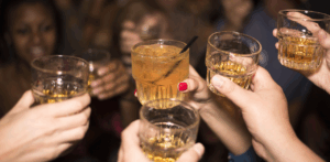 Group of people clinking glasses filled with alcohol during a night out