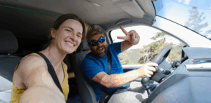 Happy couple takes a road trip selfie inside their vehicle, smiling and enjoying the ride