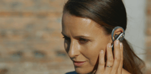 Woman uses a wireless Bluetooth headset for hands-free communication outdoors