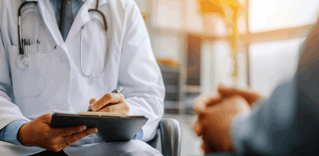 Doctor taking notes during a medical consultation with a patient