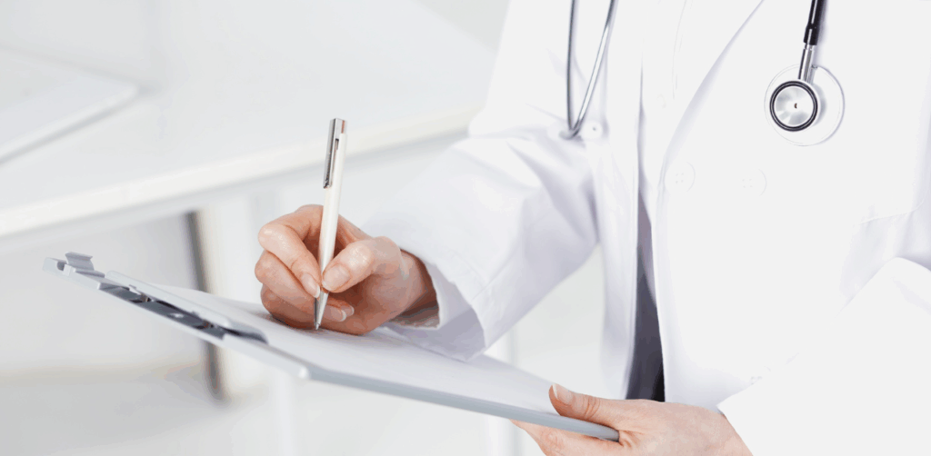 Doctor writing on clipboard during patient consultation