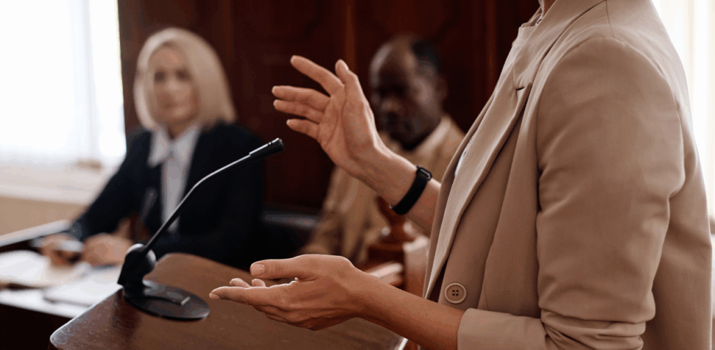 Lawyer speaking in courtroom while others listen