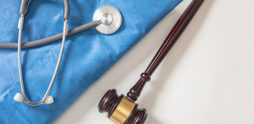 Medical malpractice concept with gavel and stethoscope on blue scrubs