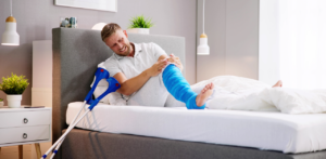 Man with leg cast using crutches while recovering from injury at home