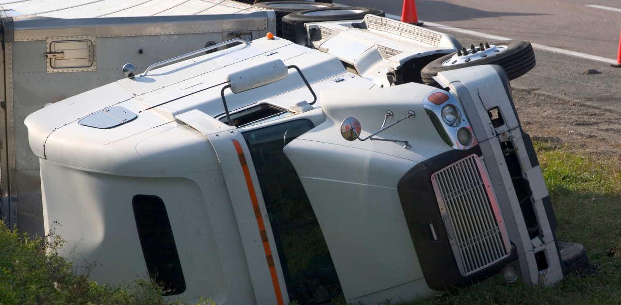 Overturned semi-truck on roadside after traffic accident, highlighting highway safety risks and heavy vehicle crashes